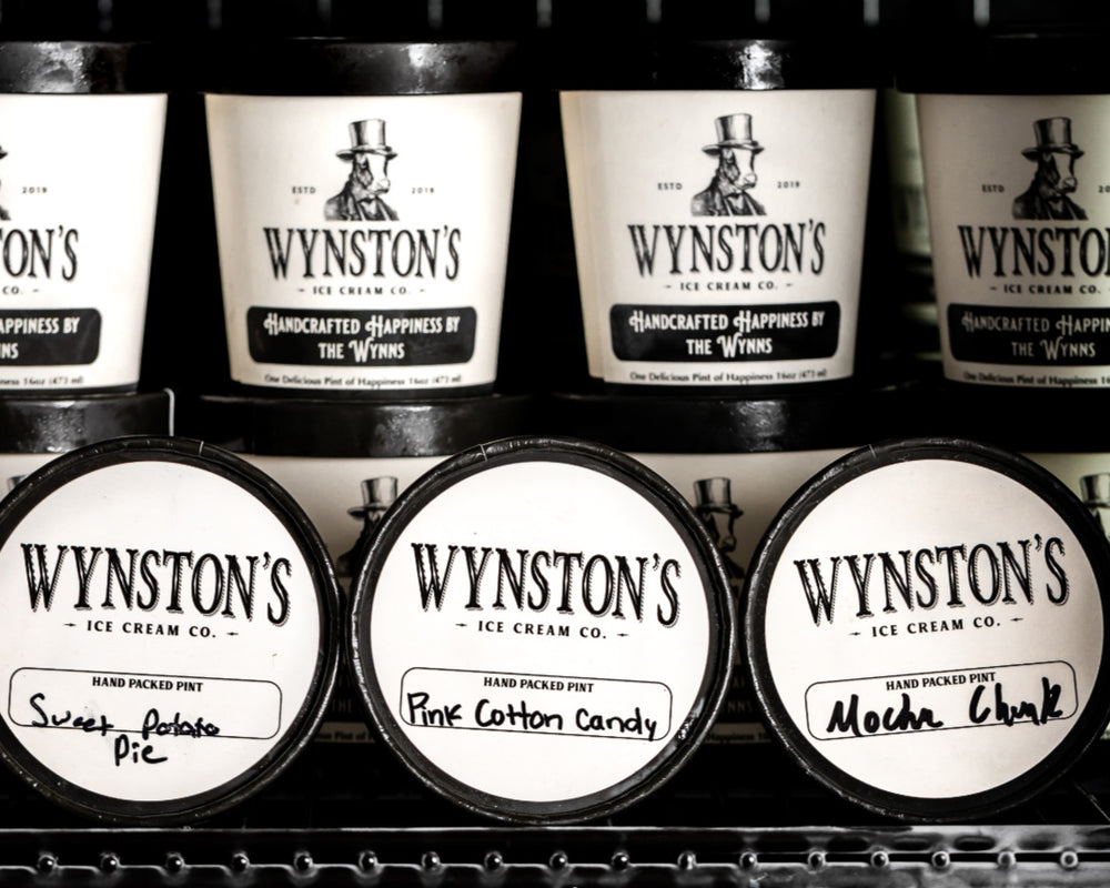 Display of Wynston's ice cream pints with labels on a shelf.